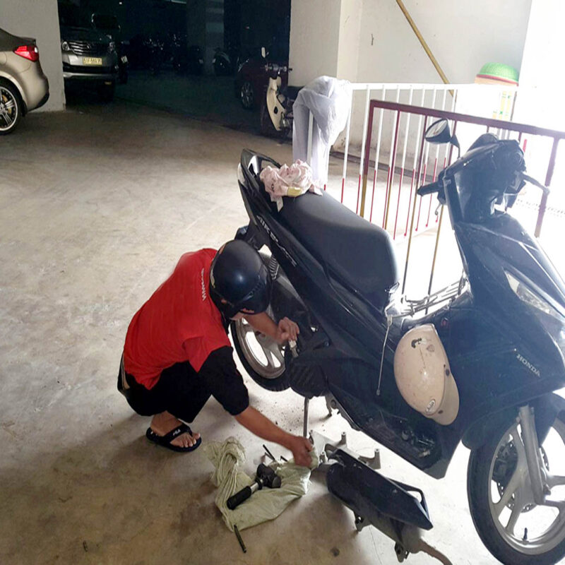 Thợ Minh Thành Motor đang sửa xe máy tại nhà khách hàng