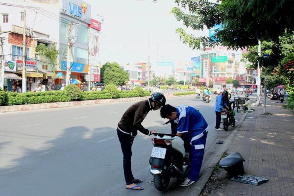 Thợ sửa xe máy lưu động tại Bình Thạnh đang kiểm tra xe hỏng trên đường